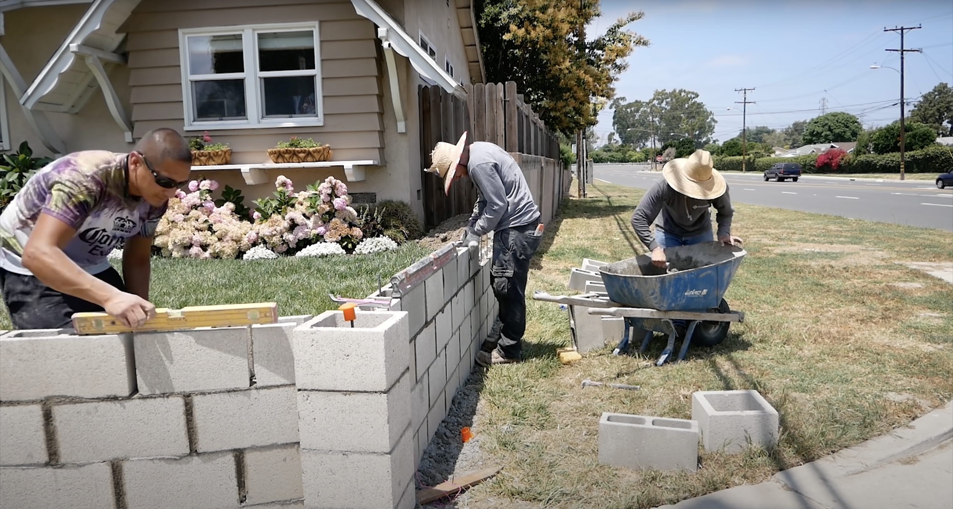 Concrete construction crew building retaining wall with proper equipment